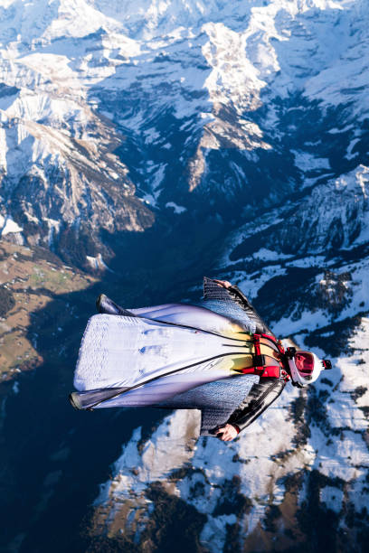 istock Wing suit soars above mountain landscape 1309139663