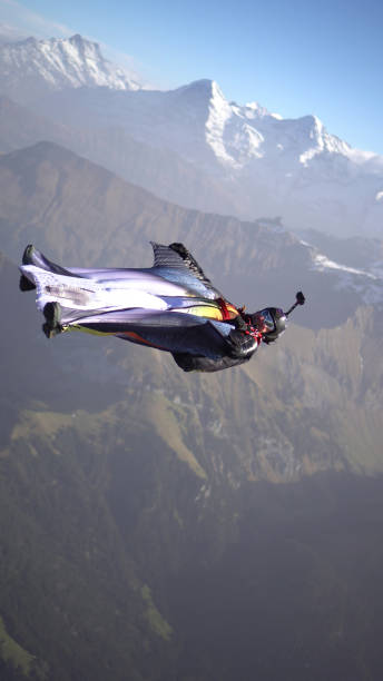 istock Wing suit soars above mountain landscape 1309139714