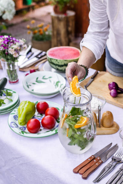 istock Woman preparing cold drink and setting dining table for garden party 1309140305