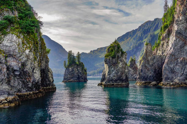 Spire Cove Rock Formations and Turquoise Waters of Spire Cove in the Kenai Fjords National Park. Seward, Alaska bay of water stock pictures, royalty-free photos & images