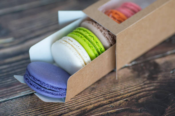 istock Close-up, macaroon cakes in paper box on dark background 1309141739