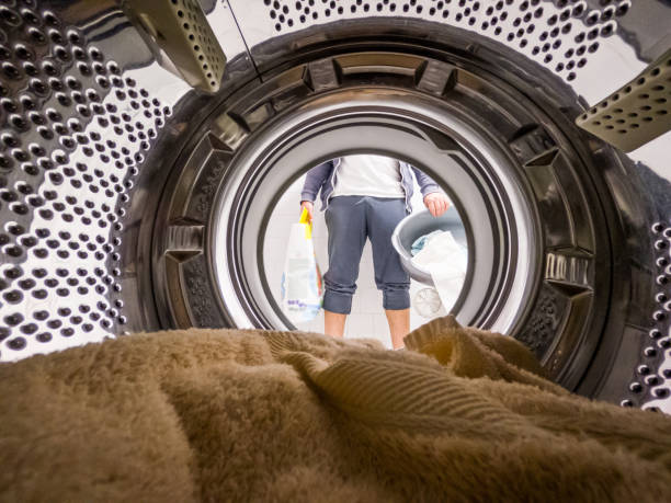 joven lavando su ropa. retrato del hombre - vista desde la lavadora en el interior - all laundry detergent audio fotografías e imágenes de stock
