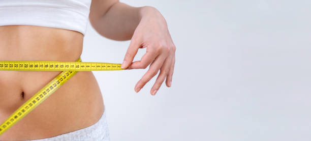 istock woman measuring her waist 1309147399