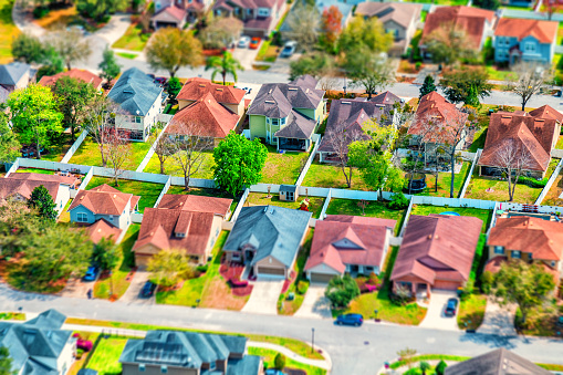 Full frame, aerial view of a group of houses in a residential development using a tilt-shift technique to make the homes appear as a possible miniature model.