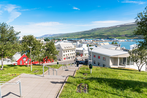 Outdoor staircase going down a hill overlooking a beautiful coastal city in Iceland on a sunny spring day. Akureyri, Iceland.