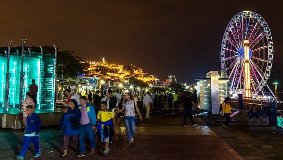 Families enjoying the Guayaquil's Malecon 2000, along the Guayas River, in the city downtown. Visible in the foreground is the Donors’ Pavilion memorial and the Ferris Wheel in the background
