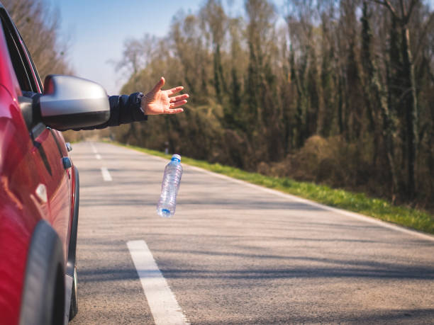 istock Driver throwing away plastic waste from the car 1309160825