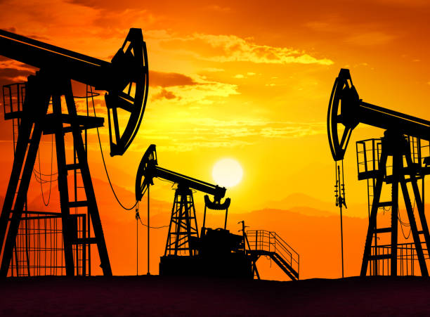istock Sunset over drilling rig petroleum pump in the desert 1309163326