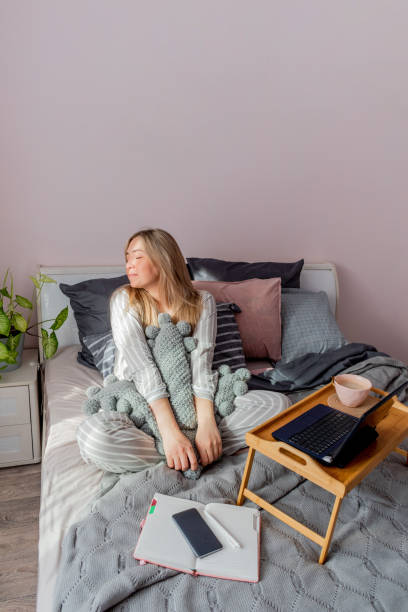 istock Defocus. Young business woman meditates while sitting on the bed, after work Internet using a computer 1309164318