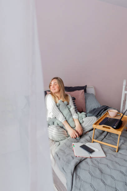 istock Defocus. Young business woman meditates while sitting on the bed, after work Internet using a computer 1309164818