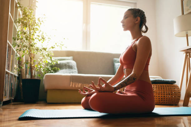 istock Young woman meditating at home 1309165076