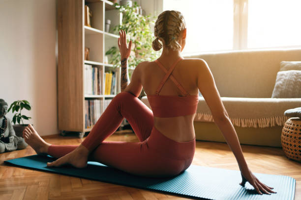 istock Back view of a young woman doing spinal twist pose 1309165096
