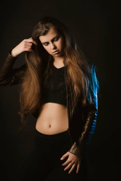 istock Glamorous young model with long hair posing at studio with blue light 1309166359