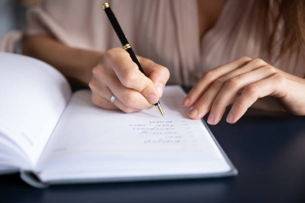 istock Close up businesswoman writing in notebook, planning workday, managing time 1309167656