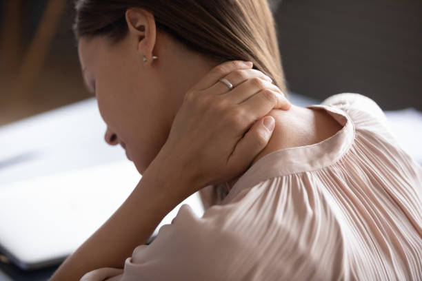 緊張した首の筋肉をマッサージに触れる疲れ果てた女性を閉じる - human spine posture back backache ストックフォトと画像