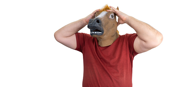 man in a horse mask isolated on a white background. a man grabs his head, the concept of hopelessness and doom