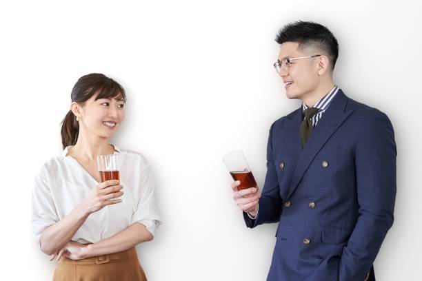 asiatisk affärsman som håller ett glas och pratar på en utbytesfest - speed dating bildbanksfoton och bilder