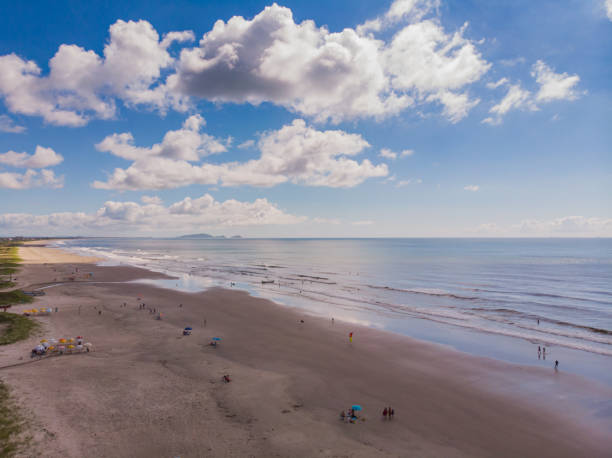 beach seen from the top Aerial image of the shore of Ipanema beach, in Pontal do Paraná, in southern Brazil with waves crashing on the sand on a blue sky day with clouds rio parana stock pictures, royalty-free photos & images