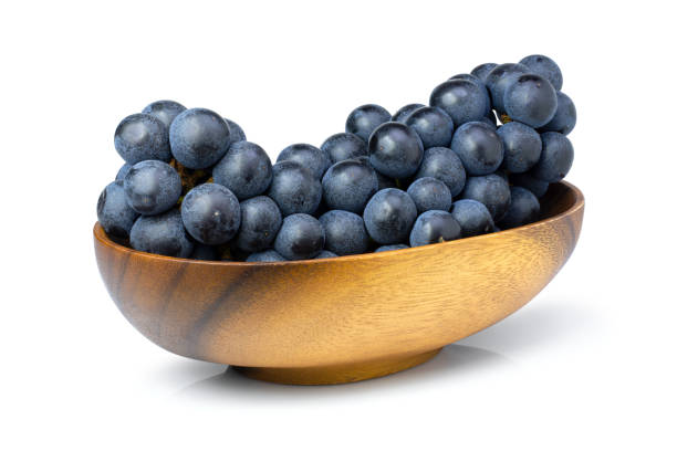 istock Black seadless grape in wooden bowl isolated on white 1309200749