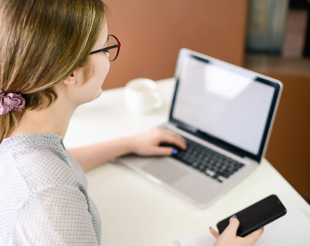 istock young woman working from home using smart phone and computer, woman's hands using smart phone in interior, at home workplace using technology 1309202317
