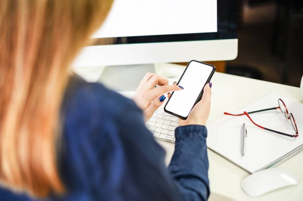 istock cropped shot of a young woman working from home using smart phone and computer, woman's hands using smart phone in interior, woman at home workplace using technology 1309202376