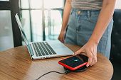 Charging mobile phone battery with wireless charging device in the table. Smartphone charging on a charging pad. Mobile phone near wireless charger Modern lifestyle concept.