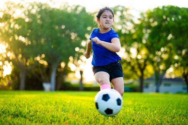 istock Girl kicking a soccer ball 1309206038