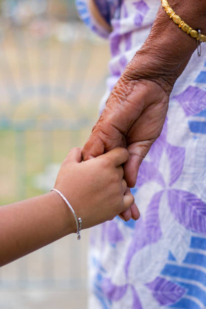 a grandmother holding hand of her granddaughter. - toddler music asian ethnicity child imagens e fotografias de stock