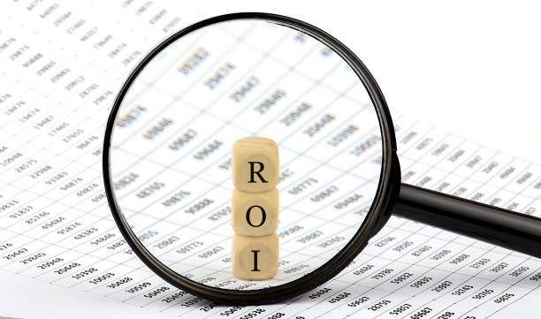 istock ROI wooden cubes on chart background , look through a magnifier 1309209646