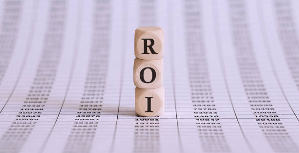istock ROI word written on wood block on the chart background . 1309209659