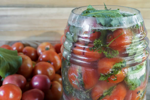 istock Ripe salted tomatoes in a glass jar. 1309209798