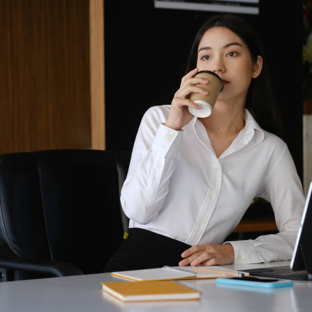 istock Young woman office worker taking a coffee break at her workplace. 1309210844
