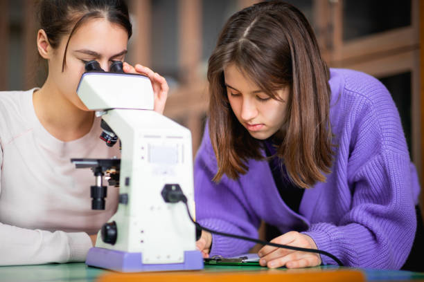 Students use a microscope and write down the results of observations