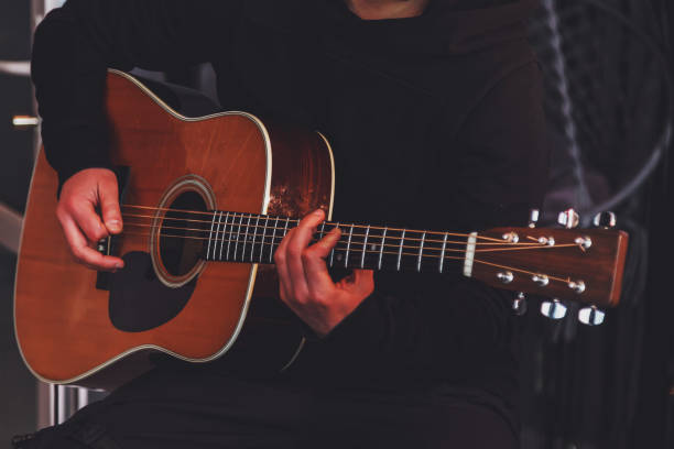 istock Guitar man holding in hands and playing acoustic guitar 1309212946