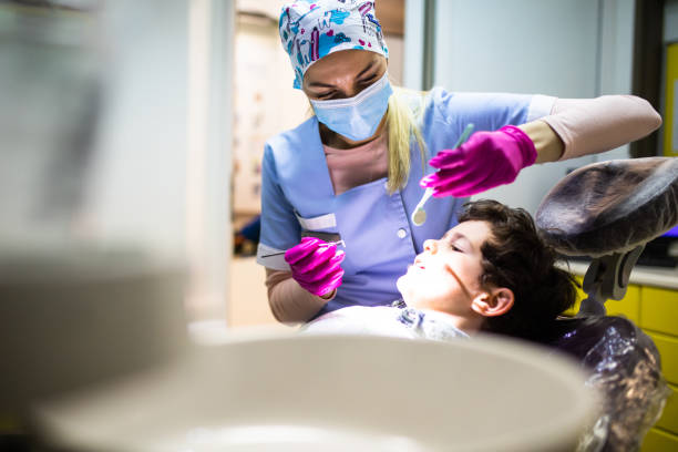 istock A female dentist about to check a young boy's teeth 1309215996