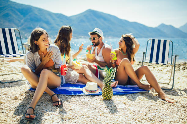 晴れた日にビーチで楽しんでいる若い友人。パーティーの時間。 - friends on the beach ストックフォトと画像