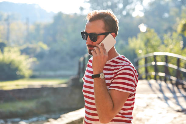 Young adult man using modern smartphone in the park.