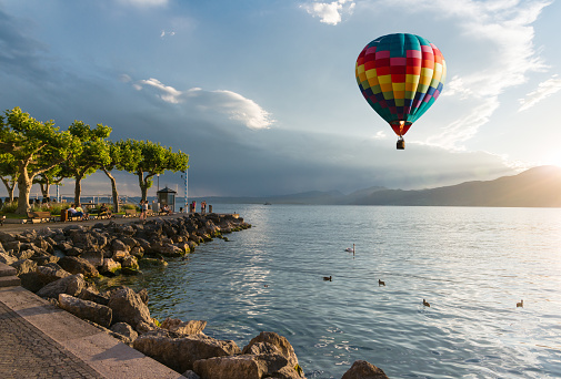 Travel in Italy, hot air balloon over Garda lake at sunset
