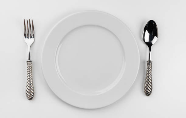 istock Empty plate with cutlery isolated on white background 1309218973