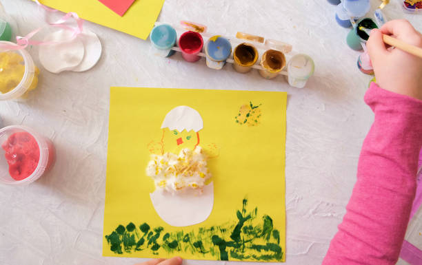 istock Child making card with Easter chick from colorful paper and cotton pad. Handmade. 1309227396