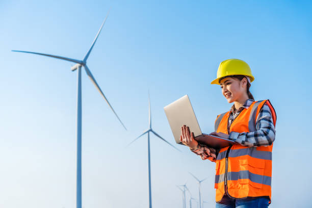 istock female engineer working with laptop computer against wind turbine farm 1309227584