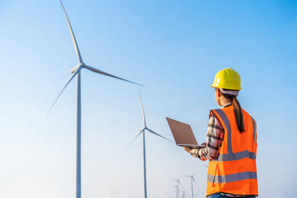 istock female engineer working with laptop computer against wind turbine farm 1309227585