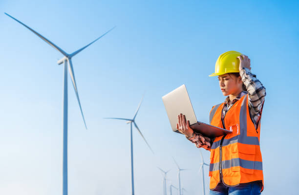 istock stressed female engineer having problem to working with laptop computer against wind turbine farm 1309227593