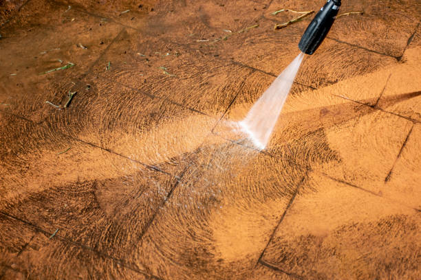 istock Cleaning backyard paving tiles with pressure washer. 1309227636