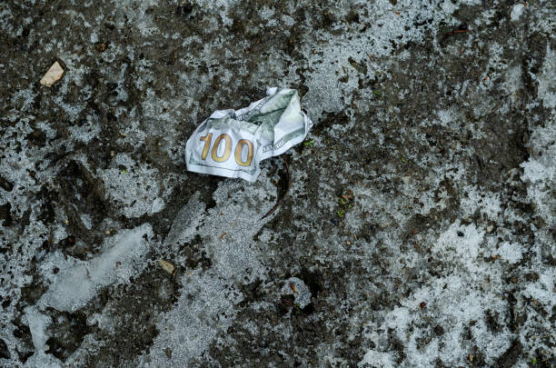 a crumpled $ 100 bill lies on the frozen ground. lost money. - crumpled currency dollar folded imagens e fotografias de stock