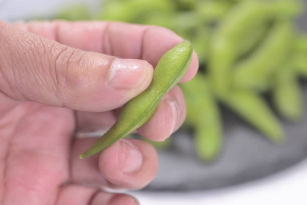 Green soybeans and fingers