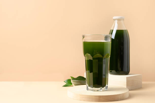 Chlorella Detox drink in glass on beige. Close up.