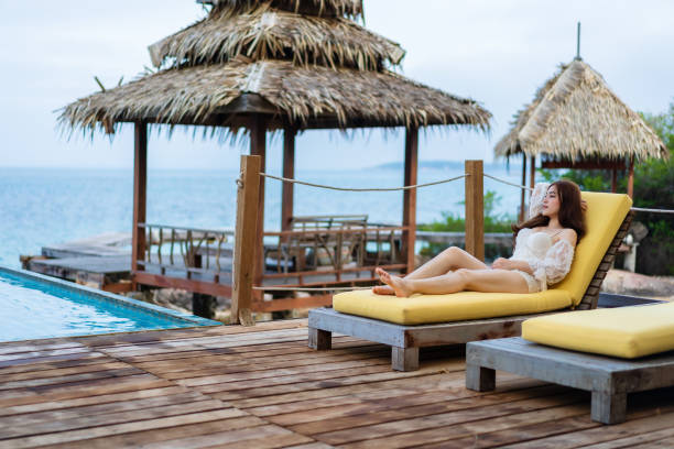 istock woman relax on deck chair in pool with sea background 1309228917