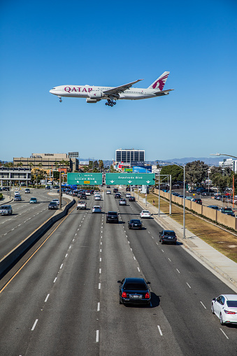 Los Angeles, California, USA - October 19, 2018: Boeing 777 Qatar Airways landing at LAX (Tom Bradley International Airport) in Los Angeles at mid day over traffic city streets.