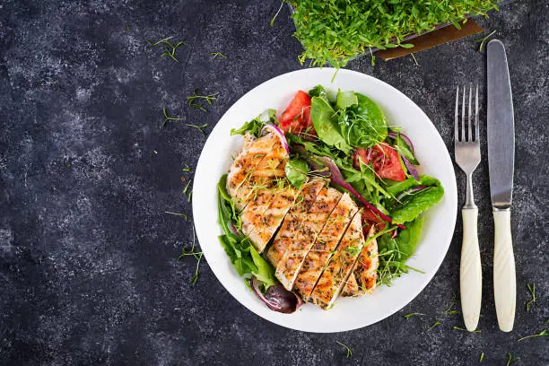 Photo of Grilled chicken fillet with salad. Keto, ketogenic, paleo diet. Healthy food.  Diet lunch concept. Top view, overhead, copy space